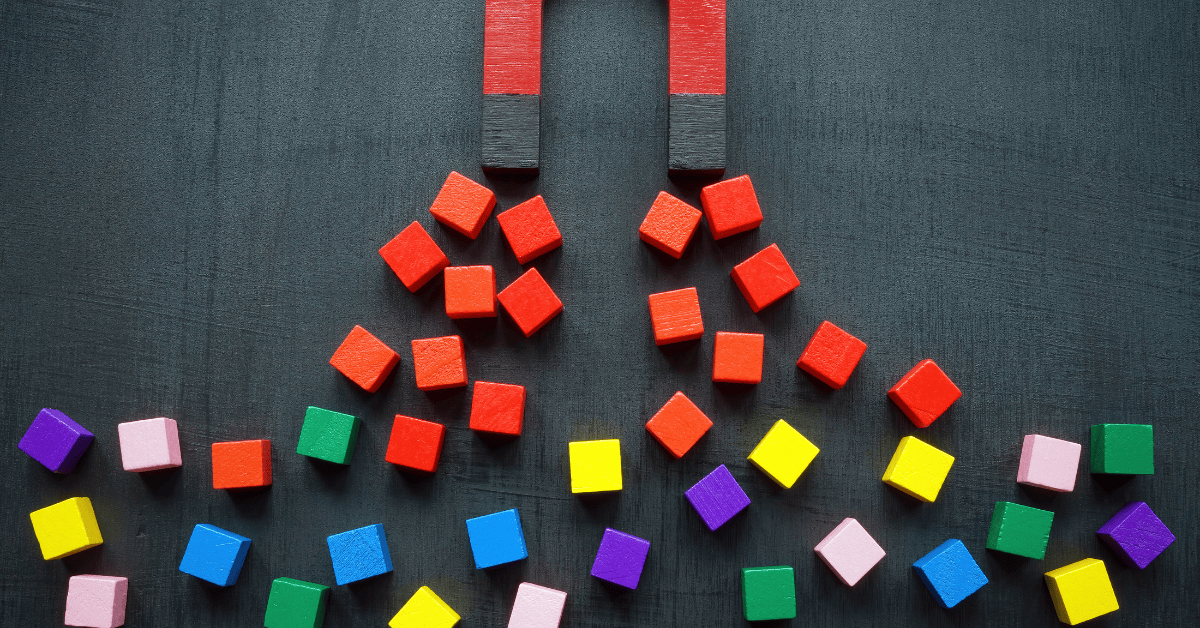 Two magnets attracting red blocks, with other colourful blocks nearby. Symbolises how effective leadership development for retention pulls talent closer.