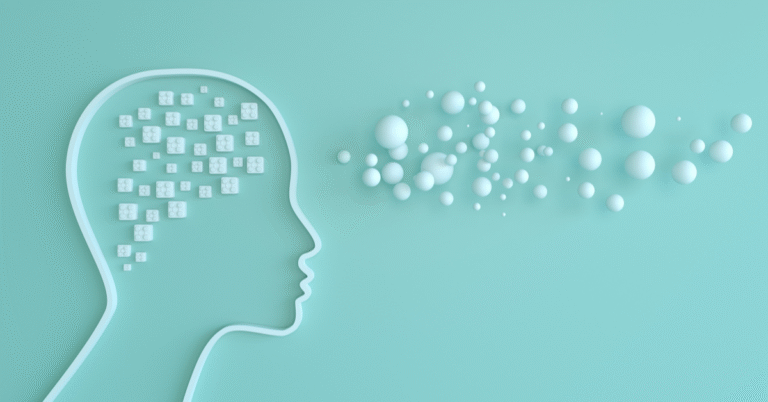 A profile outline of a human head on a mint green background, with many small white cubes inside the head representing thoughts or data, and a cloud of white spheres floating outwards from the forehead, symbolizing ideas or communication. This image relates to emotional intelligence.
