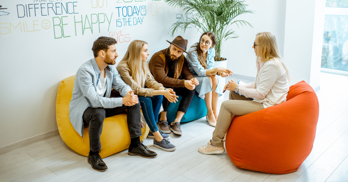 A team of 5 people talking, representing psychological safety.